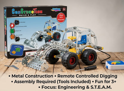 A metal construction toy set shown with its retail box on a tabletop. The set includes a silver excavator-style digging vehicle with black wheels and red wheel hubs, loose metal parts, a small remote control, and accessories.