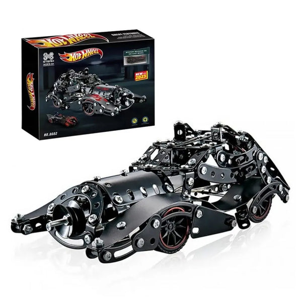 Metallic toy car chassis with Hot Wheels packaging in the background